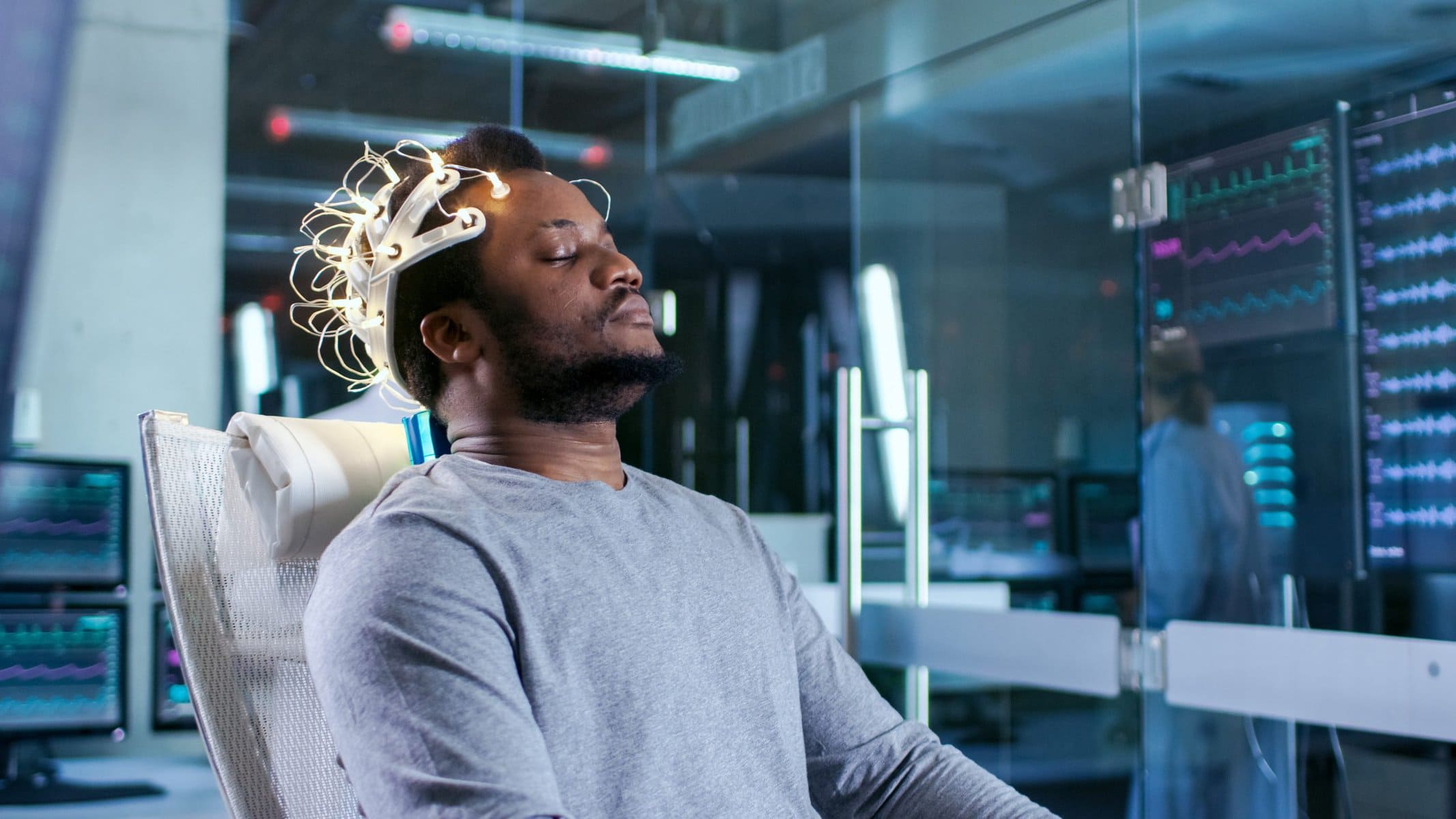 In Laboratory Man Wearing Brainwave Scanning Headset Sits in a chair with closed eyes