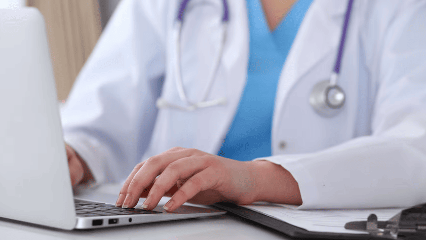 doctor typing on laptop